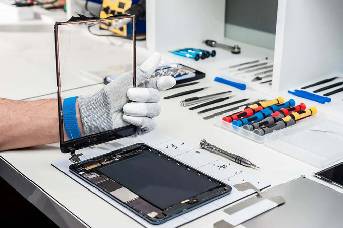 Tablet repair services with an expert technician fixing a device on a workspace filled with tools