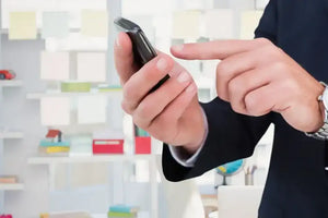 Black smartphone held in hand, sleek and modern design with a glossy finish.