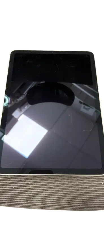 Black ipad air 10.9-inch 5th gen tablet with cracked screen and scratches on textured surface for phone repair